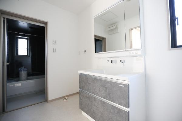 AG-HOUSE　ゆめが丘　B棟の独立洗面台|洗面台には大きな鏡が設置されておりシンプルなデザインが空間を広く感じさせます。収納力のある引き出しが備わっているので日用品の整理も容易です。明るい窓から自然光が入り清潔感を感じられる洗面所です。