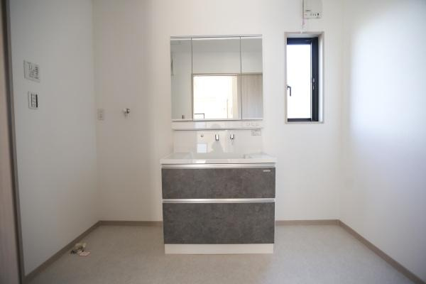 AG-HOUSE　ゆめが丘　B棟の独立洗面台|洗面台・洗面所は明るい空間でシンプルなデザインが特徴です。鏡面収納が備わっており収納力があります。窓からの採光で清潔感が感じられます。床や壁も落ち着いた色合いで全体的にすっきりとした印象です。
