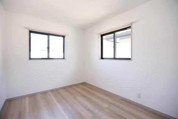 AG-HOUSE　ゆめが丘　A棟の洋室|2つの窓から自然光がたっぷり入る洋室です。シンプルな白い壁と木目調の床が清潔感を演出しています。家具の配置がしやすいレイアウトです。