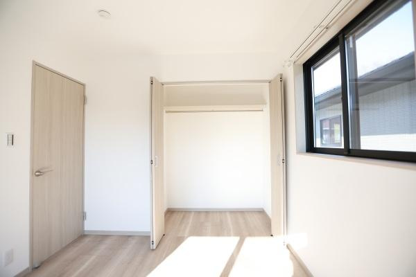 AG-HOUSE　ゆめが丘　A棟の収納|ナチュラルな木目調のドアとクローゼットが室内に調和しています。大きめの窓から光が差し込み収納スペースも明るい雰囲気です。室内がすっきりとした印象になります。