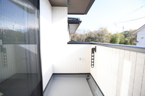AG-HOUSE　ゆめが丘　A棟のバルコニー|バルコニーは清潔感のある明るい空間です。しっかりとした壁に囲まれており落ち着いたプライベート空間となっています。手すり部分に物干し金具が設置されていて便利です。