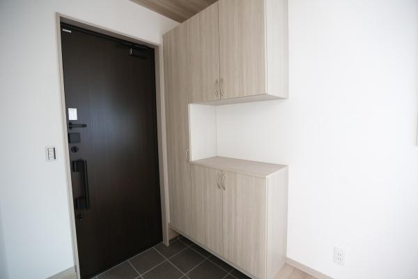 AG-HOUSE　ゆめが丘　A棟の玄関|玄関には収納スペースがしっかりと設けられており日々の出入りがスムーズに行えます。ダークトーンのドアが空間に落ち着きを与えます。