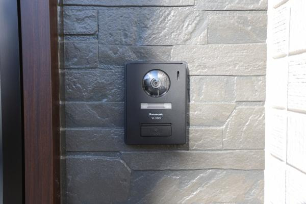 AG-HOUSE　ゆめが丘　A棟の玄関|スタイリッシュな石目調の壁に設置されたインターホンがシンプルで落ち着いた雰囲気を演出しています。玄関周りがすっきりとまとまり訪れる人にも好印象を与えます。