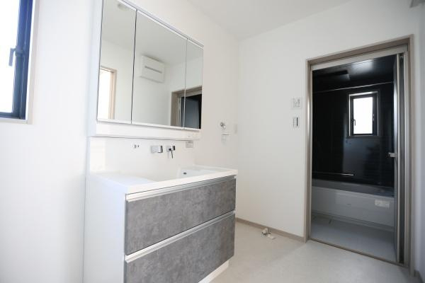 AG-HOUSE　ゆめが丘　A棟の独立洗面台|洗面台はモダンなデザインで収納も充実しています。大きなミラーが設置され空間がすっきりとしています。壁や床は明るい色で清潔感があります。