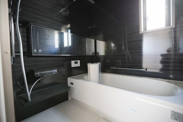 AG-HOUSE　ゆめが丘　A棟の浴室|落ち着いた色合いのパネルが印象的な浴室です。窓があり換気もスムーズに行えます。ゆったりとしたバスタブで空間にゆとりを感じられます。