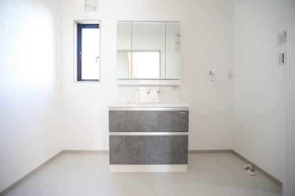 AG-HOUSE　ゆめが丘　A棟の独立洗面台|シンプルなデザインの洗面台が設置されています。明るい空間が広がり清潔感を感じられます。大きな鏡付きで使い勝手にも配慮されています。収納スペースも確保されています。