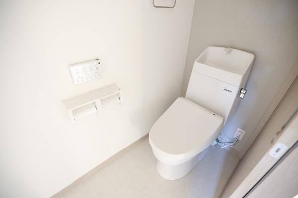 AG-HOUSE　ゆめが丘　A棟のトイレ|シンプルで清潔感のあるトイレ空間です。壁付けのリモコン操作パネルが設置されています。ペーパーホルダーも使いやすい位置に配置されています。
