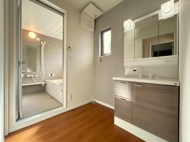 高知市朝倉己　新築一戸建ての脱衣所|大きな三面鏡と収納充実の洗面化粧台。忙しい朝もストレスフリー。