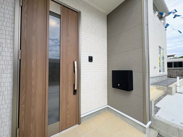 クレイドルガーデン糸満市大度 第1・２号棟の玄関|屋根付きで置き配スペースも確保できる玄関ポーチ／人感センサー付き玄関灯・TVモニター付きインターフォン・防犯カメラ