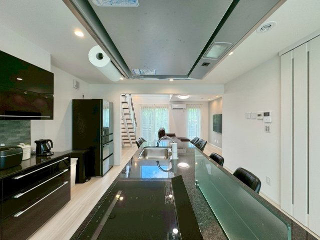 大津市大平2丁目　中古戸建ての居間・リビング|白いクロスとデザイン性の高いキッチンで清潔感と高級感を兼ね備えたLDKは広々22.25帖。