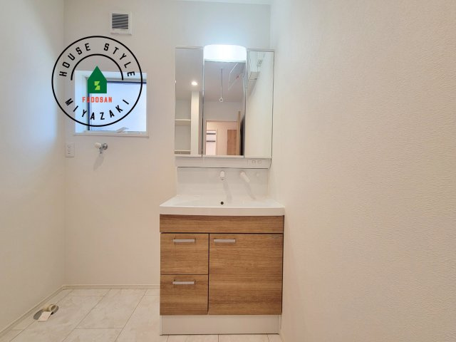 宮崎市吉村町3(1号棟)の内観：施工例|毎日使うものだから清潔な空間を保ちたい水回り。洗面にはそんな願いを解消させてくれる収納アイデアが満載です。三面鏡の裏側にはキャビネットが現れ小物から背の高い物まで収納できます。