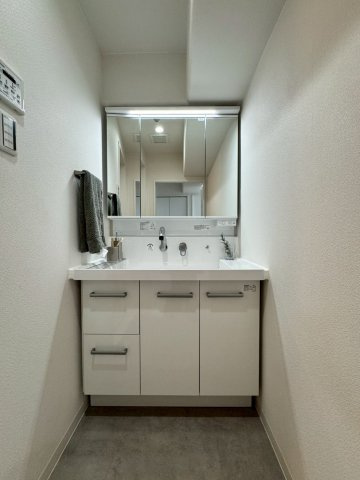 ふぁみーゆ寝屋川セントラルパークA棟の独立洗面台|リフォーム済みの明るい三面鏡付き洗面化粧台。
洗面台下はたっぷり収納できます。