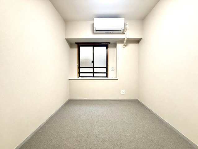 モリスガーデンヒルズ井土ヶ谷の居間・リビング|エアコン付きで一年を通して快適に過ごせる洋室。絨毯ならではの防音性と柔らかな質感が、落ち着きのある居住空間を実現します。