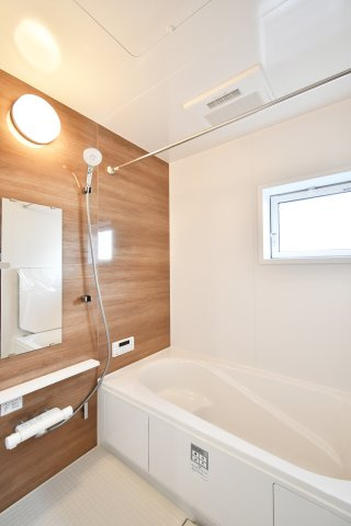 蓮田市西新宿3丁目　全1棟の浴室|白基調に木目アクセントでおしゃれな浴室。浴室乾燥機もついておりますので、日曜日の夜に出される体操着や給食着、雨の日のお洗濯も困りません！暖房機能もついているので、寒い日のお風呂も気持ち良くは入れます。