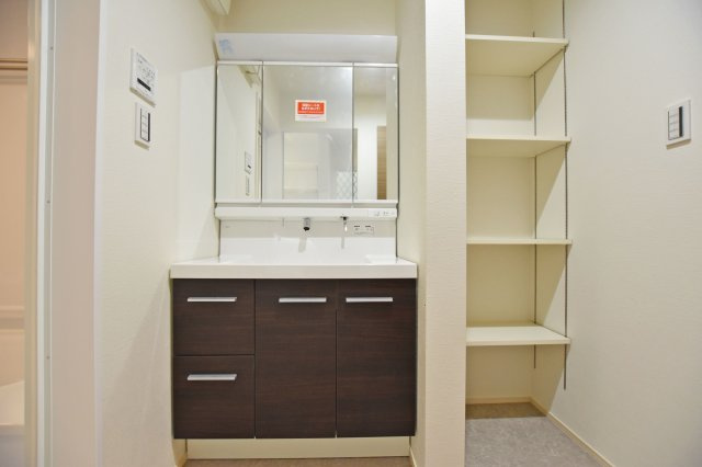 大阪市淀川区新北野3丁目新築戸建の洗面所|洗面化粧台横には可動棚もあるので、洗濯物やタオル等様々なものをスッキリと収納できます。