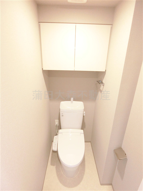 クレストコート池上のトイレ|吊戸棚とカウンター温水洗浄便座付きのトイレ　