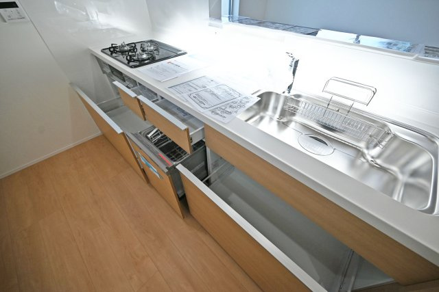 宝塚市高司1丁目新築一戸建て│3SLDK+並列駐車2台可(車種制限有)のキッチン|ワークトップは十分な広さがあるW2550タイプ。調理台下いっぱいに収納を設け、包丁のホルダーや調味料専用の引き出しも備えています。本分譲地は食洗機が標準装備されています。