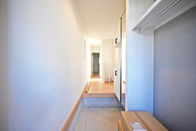 宝塚市高司1丁目新築一戸建て│3SLDK+並列駐車2台可(車種制限有)の玄関|1階玄関入ってすぐの内観写真です。シューズボックス横には枕棚とハンガーレールが配置された収納庫付きです。