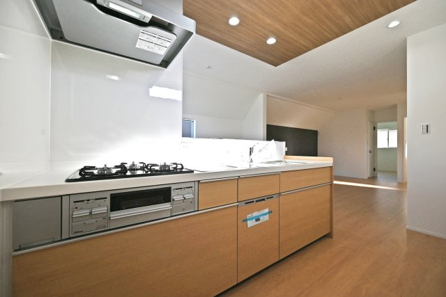 宝塚市高司1丁目新築一戸建て│3SLDK+並列駐車2台可(車種制限有)のキッチン|2階キッチン奥側から撮影した内観写真です。浄水器一体型水栓、食器洗い乾燥機などの充実した設備内容です。キッチン上部は折下天井を採用でデザイン性を向上させています。