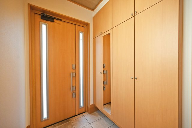 宝塚市高司3丁目中古戸建｜4LDK+駐車2台可(車種制限有)の玄関|1階玄関をホール側から撮影した内観写真です。 シンプルな玄関扉にシューズボックスを配置したオーソドックスな玄関です。