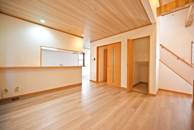 宝塚市高司3丁目中古戸建｜4LDK+駐車2台可(車種制限有)の居間・リビング|１階LDKの内観写真です。スキップフロアや対面式キッチンで家族同士のつながりを感じやすい設計を基調としています。天井に木目のアクセントクロスを採用し、魅力満載のリフォーム内容に仕上がりました。