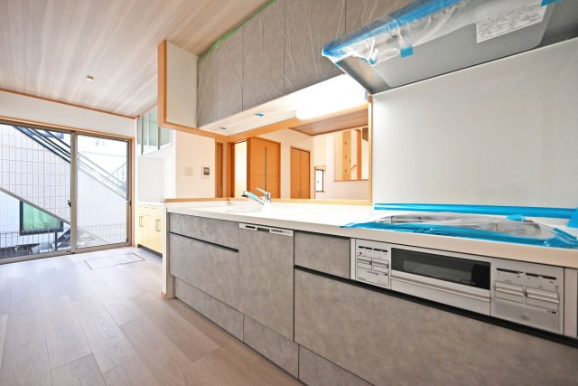 宝塚市高司3丁目中古戸建｜4LDK+駐車2台可(車種制限有)のキッチン|1階キッチンの内観写真です。食洗機が搭載されたシステムキッチン◎3口コンロでお料理の幅が広がります。 上下に収納があり収納豊富なため、常にすっきり保つことが出来ます。