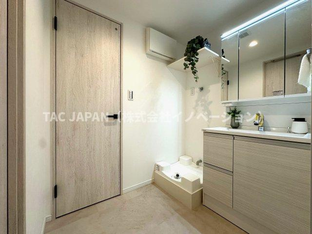 赤羽神谷サンハイツの洗面所|大型の洗濯機を置いても余裕が感じられる脱衣スペースにはお洒落な洗面ユニットを制作。キッチンスペースにも直接抜けられ家事効率も大幅UP。