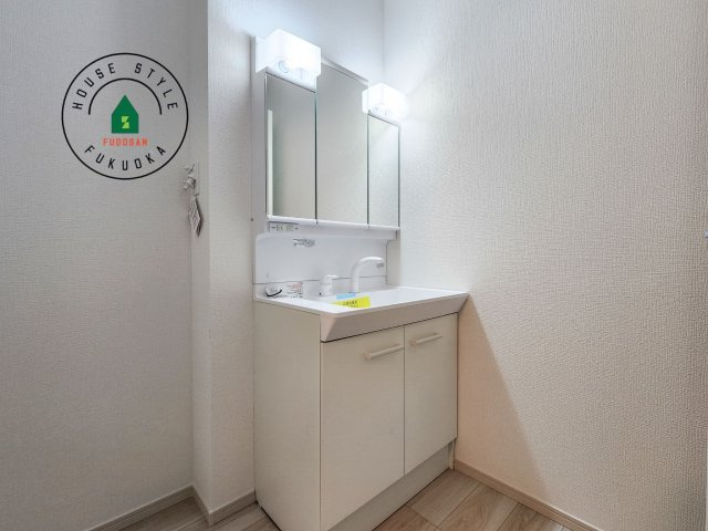 福岡市中央区港3丁目第1-1棟（1号棟）の内観：施工例|毎日使うものだから清潔な空間を保ちたい水回り。洗面にはそんな願いを解消させてくれる収納アイデアが満載です。三面鏡の裏側にはキャビネットが現れ小物から背の高い物まで収納できます。