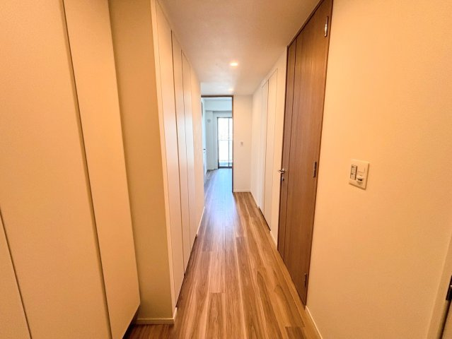 白を基調とした明るく洗練された玄関。室内へと続く廊下は、木の温もりを感じるフローリングが上質な空間を演出します。フラットな設計で移動もスムーズ。住まいの顔として、ゲストを優しく迎え入れます。