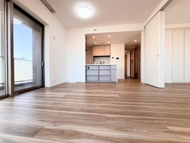 二面採光の角住戸ならではの明るいリビング。光が降り注ぐ大きな窓が開放感を演出し、家族が自然と集まる心地よい空間です。木の温もりを感じるフローリングが、上質な暮らしを優しく包み込みます。