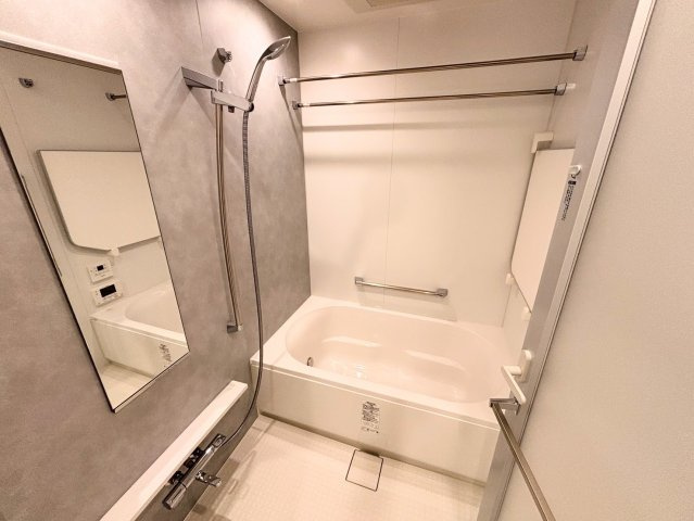 1418サイズの広々としたバスルーム。落ち着いたトーンのパネルが高級感を演出し、一日の疲れを優しく癒やします。浴室乾燥機やスライドバー付きシャワーなど、快適なバスタイムをサポートする設備も満載。