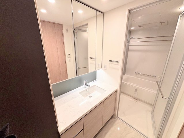 ホテルライクで洗練されたデザインの洗面化粧台。身支度がしやすい三面鏡と、広々としたカウンターが魅力です。足元や鏡裏の収納も充実しており、生活感を抑えつつスマートな毎日を叶えてくれます。