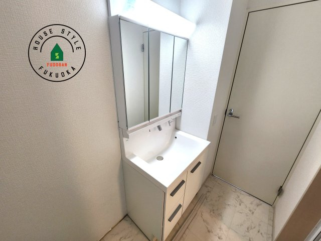 福岡市中央区港3丁目第1-1棟（1号棟）の内観：施工例|毎日使うものだから清潔な空間を保ちたい水回り。洗面にはそんな願いを解消させてくれる収納アイデアが満載です。三面鏡の裏側にはキャビネットが現れ小物から背の高い物まで収納できます。