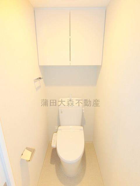 コンフォリア・リヴ大森西のトイレ|吊戸棚収納と温水洗浄便座付きのトイレ