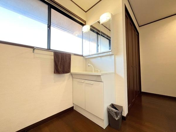 判田台南3丁目　戸建の内装|収納キャビネット付きですっきりとした印象です。明るい照明が鏡を彩っています。クローゼットも近く使い勝手が良い配置です。
