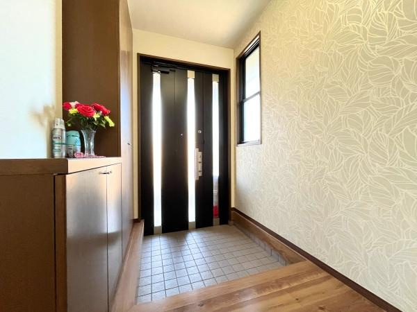 判田台南3丁目　戸建の玄関|玄関は明るい光が差し込む印象的な空間です。壁紙のデザインがシンプルで上品な雰囲気を演出しています。収納スペースも充実しておりすっきりとした印象です。