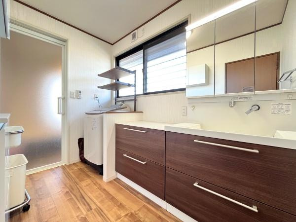 判田台南3丁目　戸建の独立洗面台|広々とした洗面台で使い勝手に配慮されています。大きな鏡と収納スペースが付いており日々の身支度もスムーズです。窓から自然光が入るので明るい印象の洗面所です。