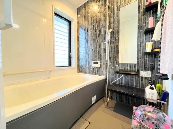 判田台南3丁目　戸建の浴室|バスルームはモダンなタイルデザインが目を引きます。窓があり通気や採光に優れています。壁面の収納棚清潔感のある空間が広がっています。