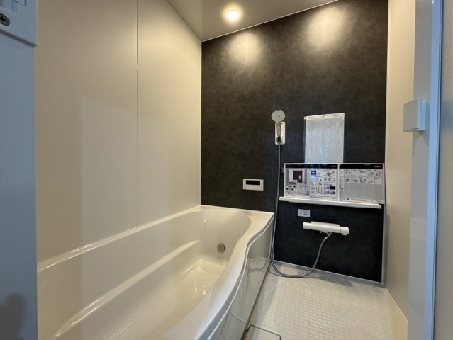 武佐3丁目【フルリノベーション】平屋の快適な暮らしを！の浴室|シックな壁が魅力！足を伸ばせる最新ユニットバス