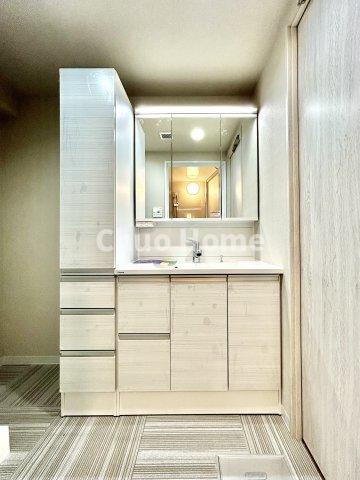 なぎさニュータウン5号棟の独立洗面台|【洗面化粧台】洗面化粧台には三面鏡を採用。身だしなみを整えやすい事はもちろんですが、鏡の後ろに収納スペースを設ける事により、散らかりやすい洗面スペースをすっきりさせる事が出来るのも嬉しいですね