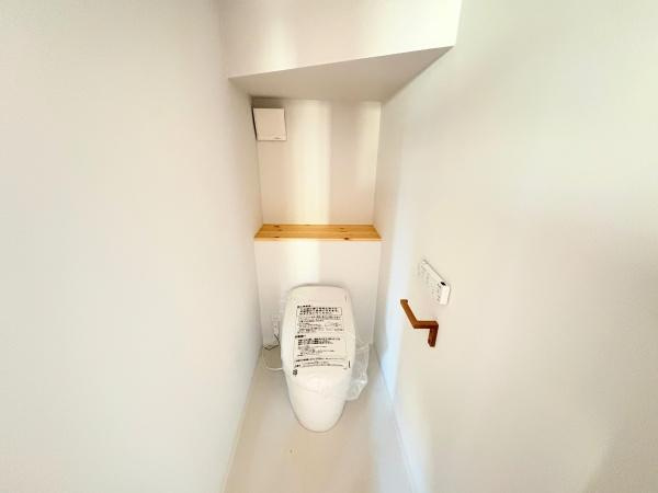 つのこばるヴィレッジ　Ｂ棟のトイレ|トイレはシンプルで清潔感があります。壁際に設けられた棚は小物の整理に便利です。ホワイトを基調とした空間で明るい印象を受けます。