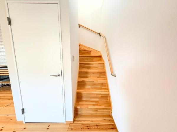 つのこばるヴィレッジ　Ｂ棟の内装|ナチュラルな木目が印象的な階段は周囲の空間と調和しています。白い壁が明るさを引き立て手すり付きで安心して昇降できます。階段下のスペースも有効活用されています。