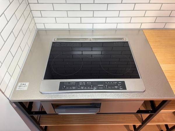つのこばるヴィレッジ　Ｂ棟のキッチン|シンプルなタイル貼りの壁が印象的なキッチンです。スタイリッシュなIHクッキングヒーターが設置されており調理スペースが確保されています。操作パネルも分かりやすくお手入れも簡単です。
