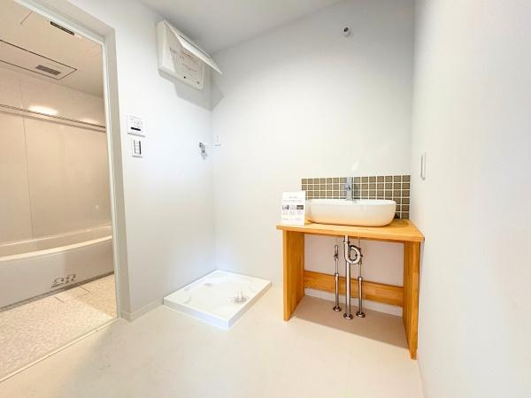 つのこばるヴィレッジ　Ｂ棟の独立洗面台|清潔感のあるシンプルな洗面台が特徴です。木製カウンターとモザイクタイルの組み合わせが印象的です。広々としたスペースで使い勝手に配慮されています。