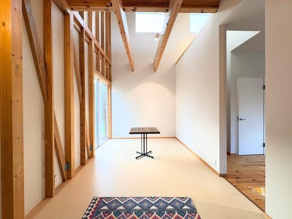 つのこばるヴィレッジ　A棟の内装|開放感のある吹き抜けが特徴的な空間です。天井部分の木梁が室内に温かみを加えています。壁には大きな窓があり自然光がしっかり差し込みます。