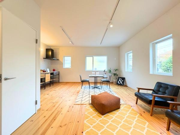 つのこばるヴィレッジ　A棟の居間・リビング|リビング全体に明るい光が差し込みナチュラルな木目の床が特徴的です。窓からの景色も楽しめる開放的な設計です。キッチンとの動線もスムーズです。