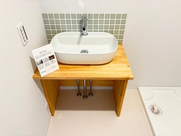 つのこばるヴィレッジ　A棟の独立洗面台|木の天板と白い洗面ボウルが調和した洗面台です。シンプルなデザインで空間をすっきり演出します。背面にはモザイクタイルがアクセントになっています。使いやすい広さも確保されています。