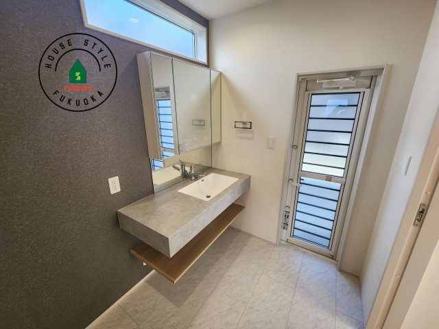 福岡市東区青葉6丁目第2-2棟（1号棟）の内観：施工例|毎日使うものだから清潔な空間を保ちたい水回り。洗面にはそんな願いを解消させてくれる収納アイデアが満載です。三面鏡の裏側にはキャビネットが現れ小物から背の高い物まで収納できます。