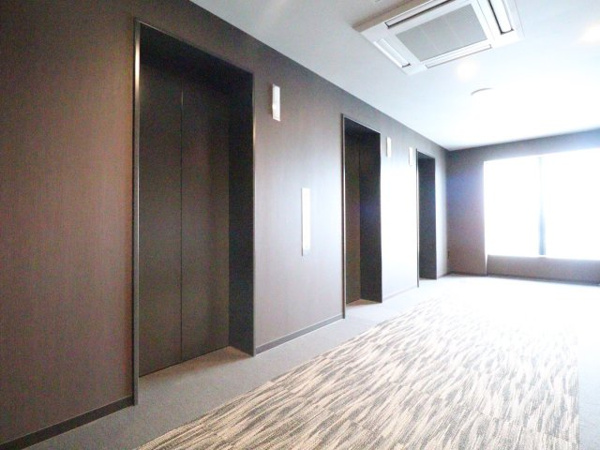【その他共用部分】 | 【居住フロア エレベータホール】落ち着いた木調仕上げと上品なカーペット敷き。素敵な眺望も楽しめます。