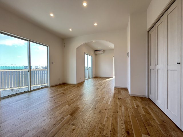 南国市大そね甲　新築一戸建ての居間・リビング|リビングとダイニングは同じ空間ながらもアーチ型の開口がゆるやか仕切り、それぞれに落ち着きを与えてくれます。窓の外は田園風景が広がります。